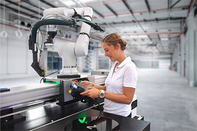 Woman operating robot-assisted adhesive application via mobile panel. 